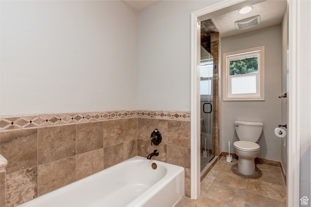 bathroom with toilet, separate shower and tub, a textured ceiling, and tile patterned flooring