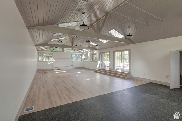 spare room with a skylight, high vaulted ceiling, and hardwood / wood-style floors