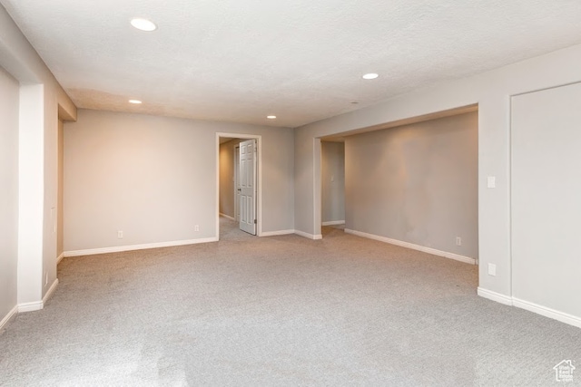 unfurnished room featuring carpet and a textured ceiling