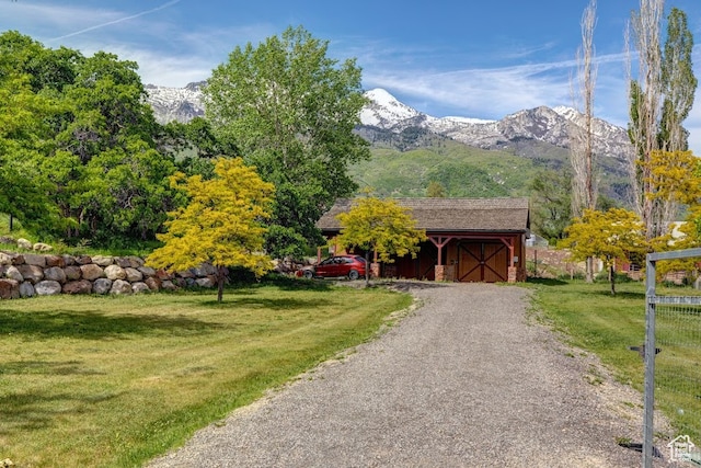 view of front of house with a mountain view and a front lawn