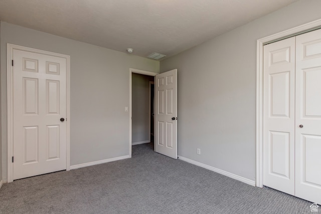 unfurnished bedroom featuring carpet and a closet