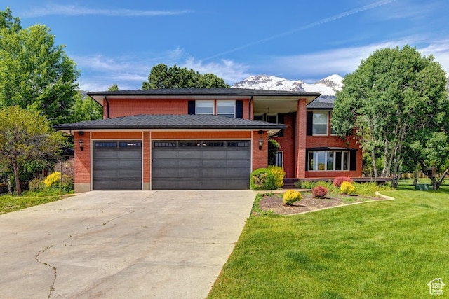 view of front of home with a garage, a mountain view, and a front yard