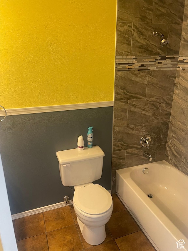 full bath with tile patterned floors, toilet, baseboards, and washtub / shower combination