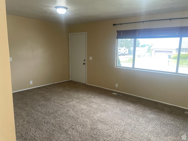 carpeted empty room with baseboards and visible vents
