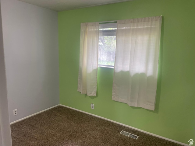 unfurnished room with carpet floors, baseboards, and visible vents
