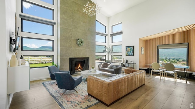 1245 E Draper Ln, Wallsburg, UT 84082 - living room with a tile fireplace, a high ceiling, light hardwood / wood-style floors, and an inviting chandelier