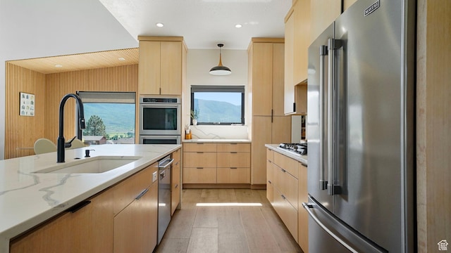 1245 E Draper Ln, Wallsburg, UT 84082 - kitchen with appliances with stainless steel finishes, light stone counters, sink, light brown cabinets, and hanging light fixtures