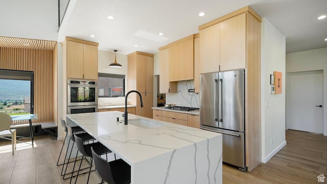 1245 E Draper Ln, Wallsburg, UT 84082 - kitchen featuring a center island with sink, hanging light fixtures, sink, light brown cabinetry, and stainless steel appliances