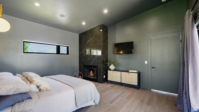 1245 E Draper Ln, Wallsburg, UT 84082 - bedroom featuring light wood-type flooring, a fireplace, and high vaulted ceiling