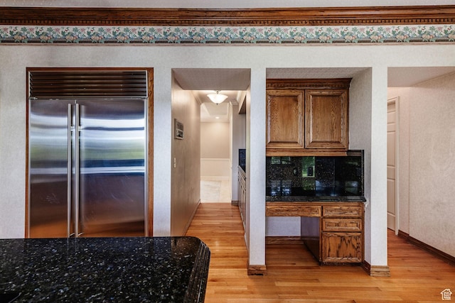 1387 E 260 N, Logan, UT 84321 - kitchen featuring backsplash, dark stone counters, crown molding, light wood-type flooring, and stainless steel built in refrigerator