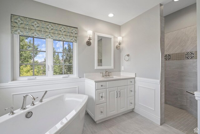3128 E Hunters Ridge Way, Heber City, UT 84032 - full bathroom featuring a freestanding tub, vanity, walk in shower, wainscoting, and a decorative wall