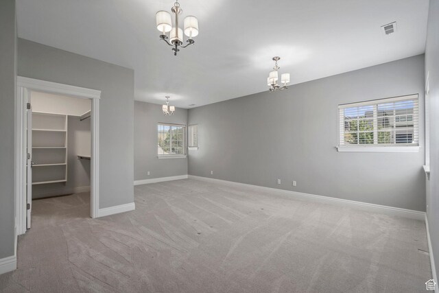 3128 E Hunters Ridge Way, Heber City, UT 84032 - unfurnished bedroom with a chandelier, a walk in closet, light carpet, baseboards, and a closet