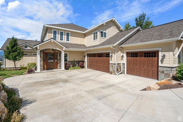 3128 E Hunters Ridge Way, Heber City, UT 84032 - view of front of home featuring driveway, stone siding, a shingled roof, and an attached garage