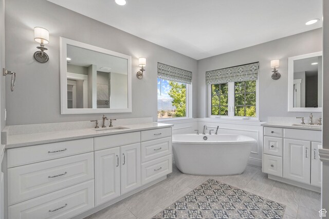 3128 E Hunters Ridge Way, Heber City, UT 84032 - bathroom featuring two vanities, a freestanding bath, and recessed lighting