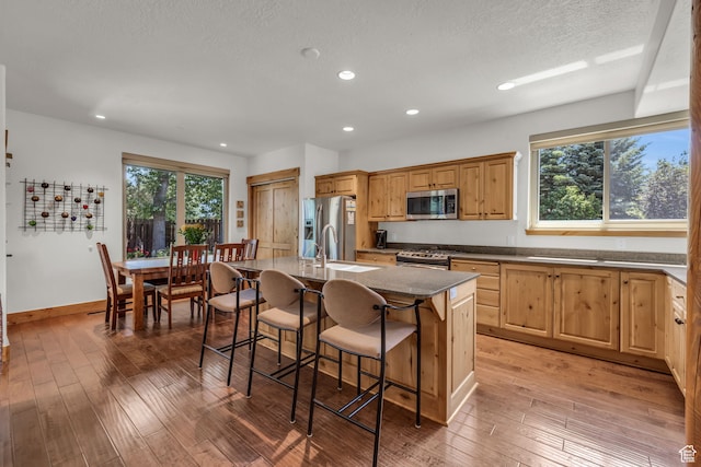 1126 Station Loop Rd, Park City, UT 84098 - kitchen featuring a kitchen breakfast bar, an island with sink, wood-type flooring, appliances with stainless steel finishes, and sink
