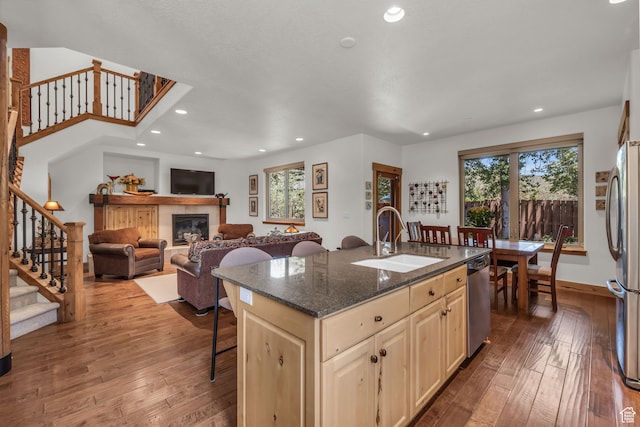 1126 Station Loop Rd, Park City, UT 84098 - kitchen featuring a tiled fireplace, a kitchen island with sink, sink, hardwood / wood-style flooring, and appliances with stainless steel finishes