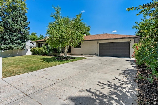 ranch-style house featuring a garage and a front yard