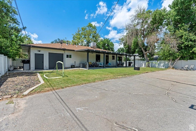 view of front of property featuring a pergola, a garage, and a front yard