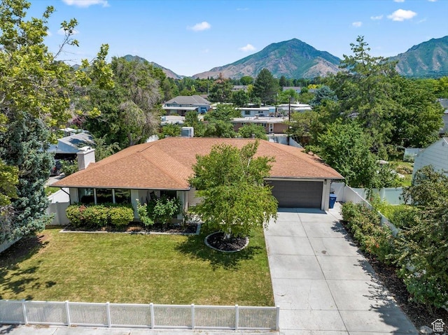 view of front facade featuring a mountain view, a garage, and a front yard