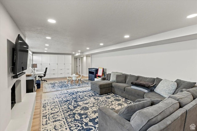 living room with a textured ceiling and light hardwood / wood-style floors