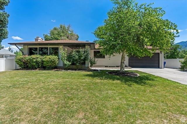 view of front of property with a garage and a front lawn