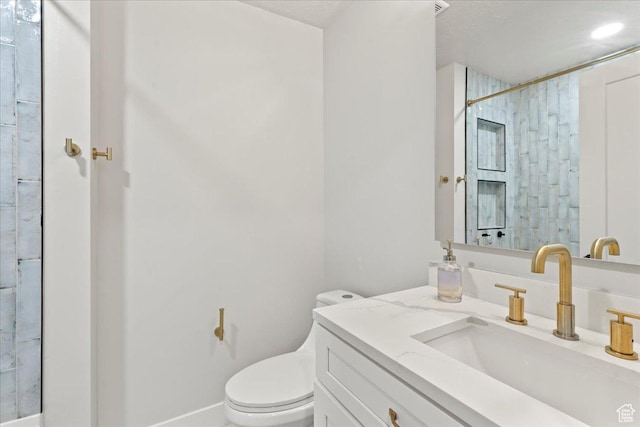 bathroom with walk in shower, vanity, and toilet