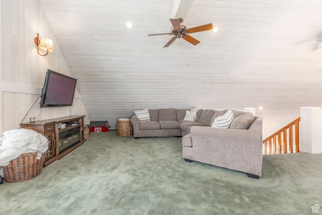 carpeted living room featuring ceiling fan, wood walls, and lofted ceiling
