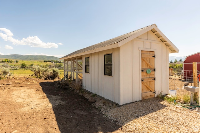 view of shed / structure with a mountain view and a rural view