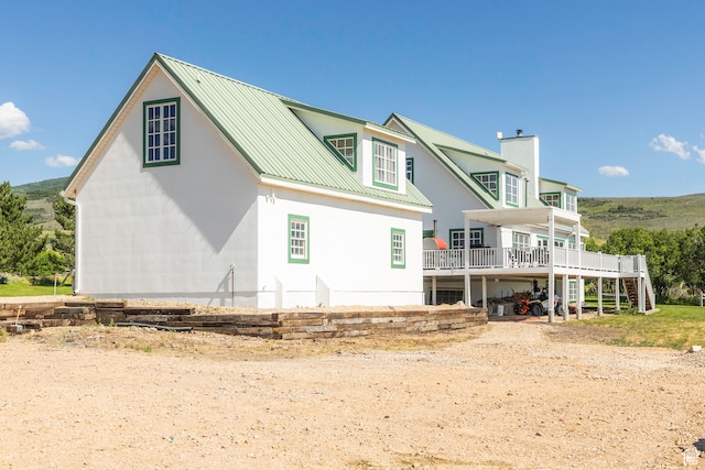 back of house with a deck