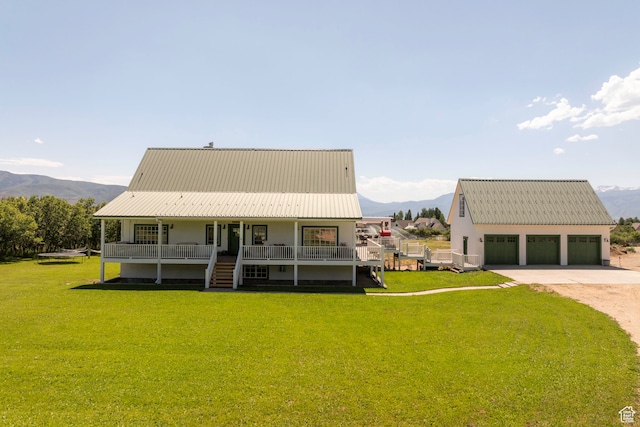 view of front of house with a garage, a front yard, a mountain view, and a porch