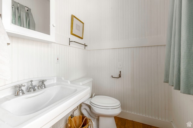 bathroom with sink, hardwood / wood-style flooring, and toilet
