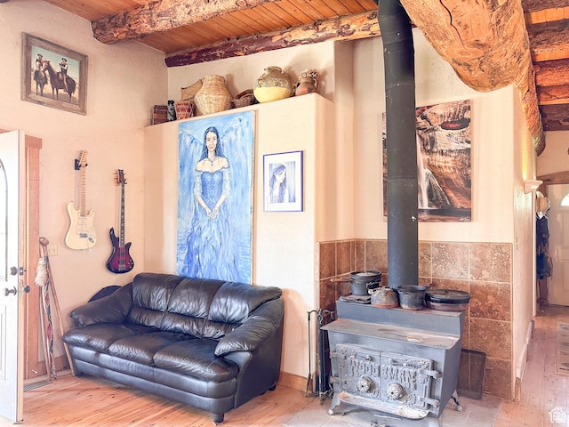 living room with beam ceiling, wood-type flooring, wooden ceiling, and a wood stove