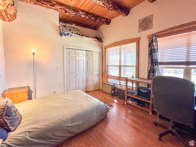 bedroom featuring hardwood / wood-style flooring, wooden ceiling, multiple windows, and beamed ceiling