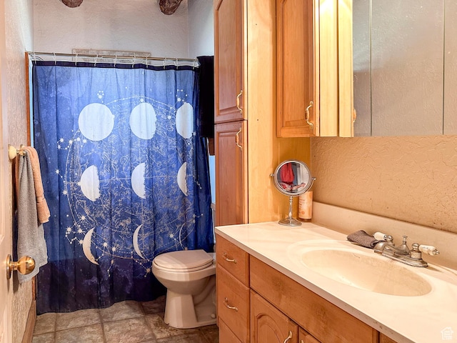 bathroom with vanity, curtained shower, and toilet