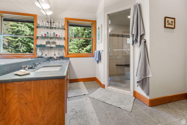 9443 E Wild Clematis Ln Unit 1, Brighton, UT 84121 - full bathroom with a sink, baseboards, tile patterned floors, double vanity, and a stall shower