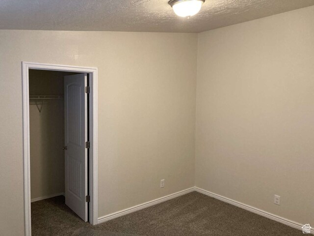 255 S 800 W, Escalante, UT 84726 - unfurnished bedroom featuring a textured ceiling, a closet, lofted ceiling, and dark carpet