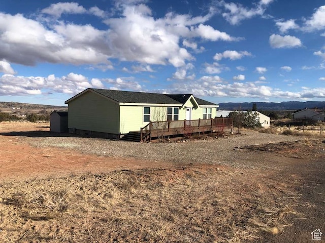 view of property exterior featuring a shed and a deck