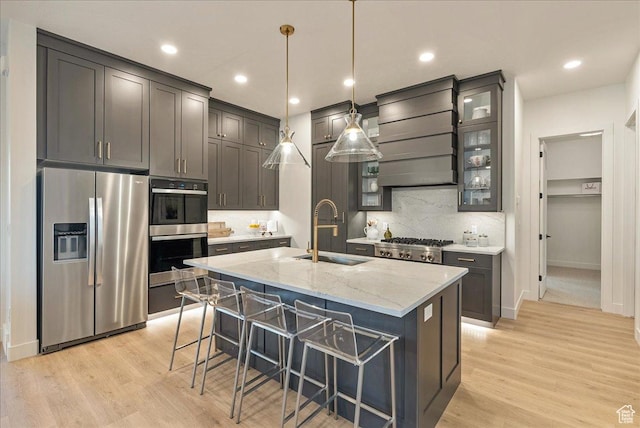 1901 S Sawmill Blvd E Unit 415, Heber City, UT 84032 - kitchen featuring a kitchen island with sink, sink, appliances with stainless steel finishes, light stone counters, and custom range hood