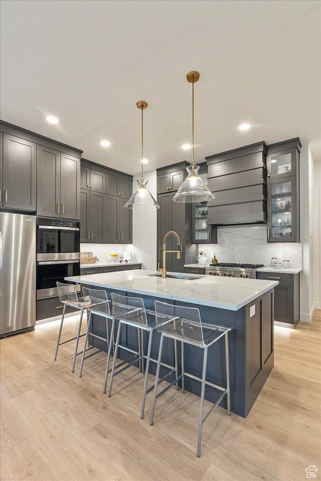 1901 S Sawmill Blvd E Unit 415, Heber City, UT 84032 - kitchen with a spacious island, sink, light wood-type flooring, appliances with stainless steel finishes, and decorative light fixtures