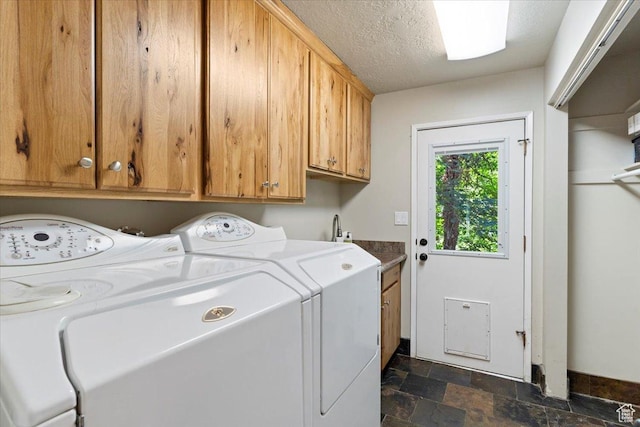 laundry room featuring cabinets, washer and dryer, and a textured ceiling