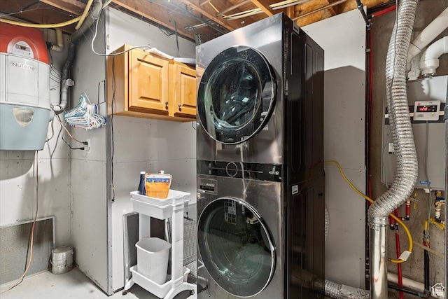 laundry room with cabinets and stacked washer and dryer