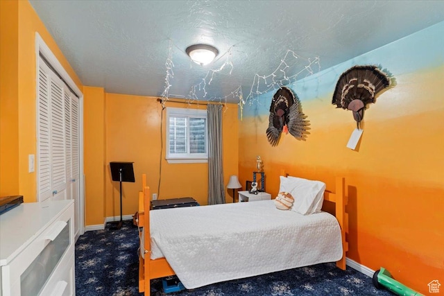 carpeted bedroom with a textured ceiling and a closet