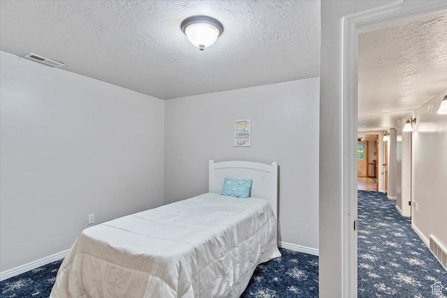 carpeted bedroom with a textured ceiling