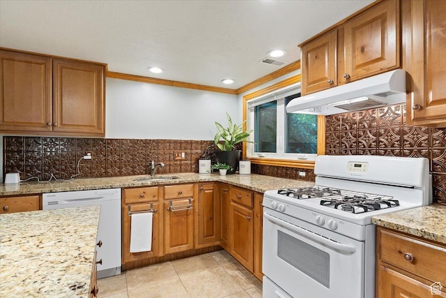 kitchen with decorative backsplash, light stone counters, white appliances, crown molding, and sink
