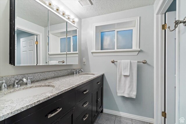 bathroom featuring vanity, a textured ceiling, and tile patterned floors