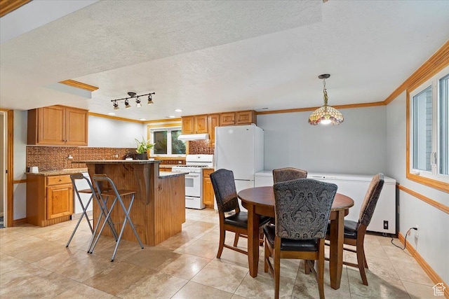 dining room with ornamental molding and a textured ceiling