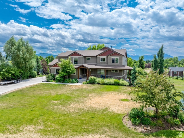 view of front of property with a mountain view and a front lawn