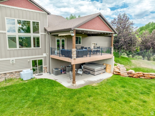 back of house featuring a lawn, a jacuzzi, a patio, and central air condition unit