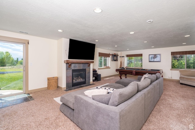 living room featuring a healthy amount of sunlight, light carpet, and a tile fireplace