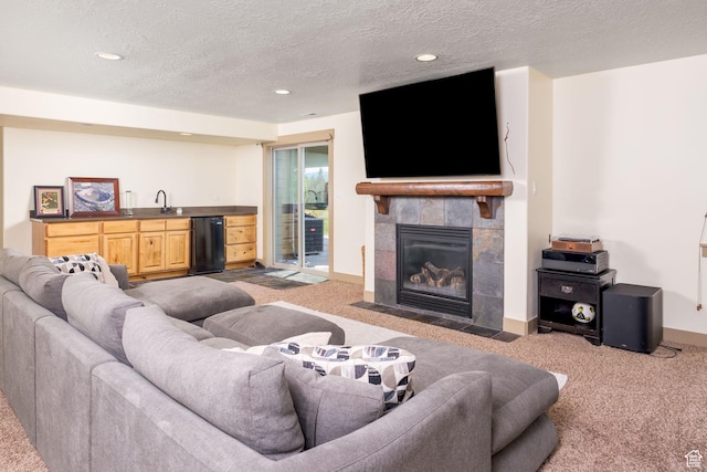 carpeted living room featuring indoor wet bar, a textured ceiling, and a fireplace